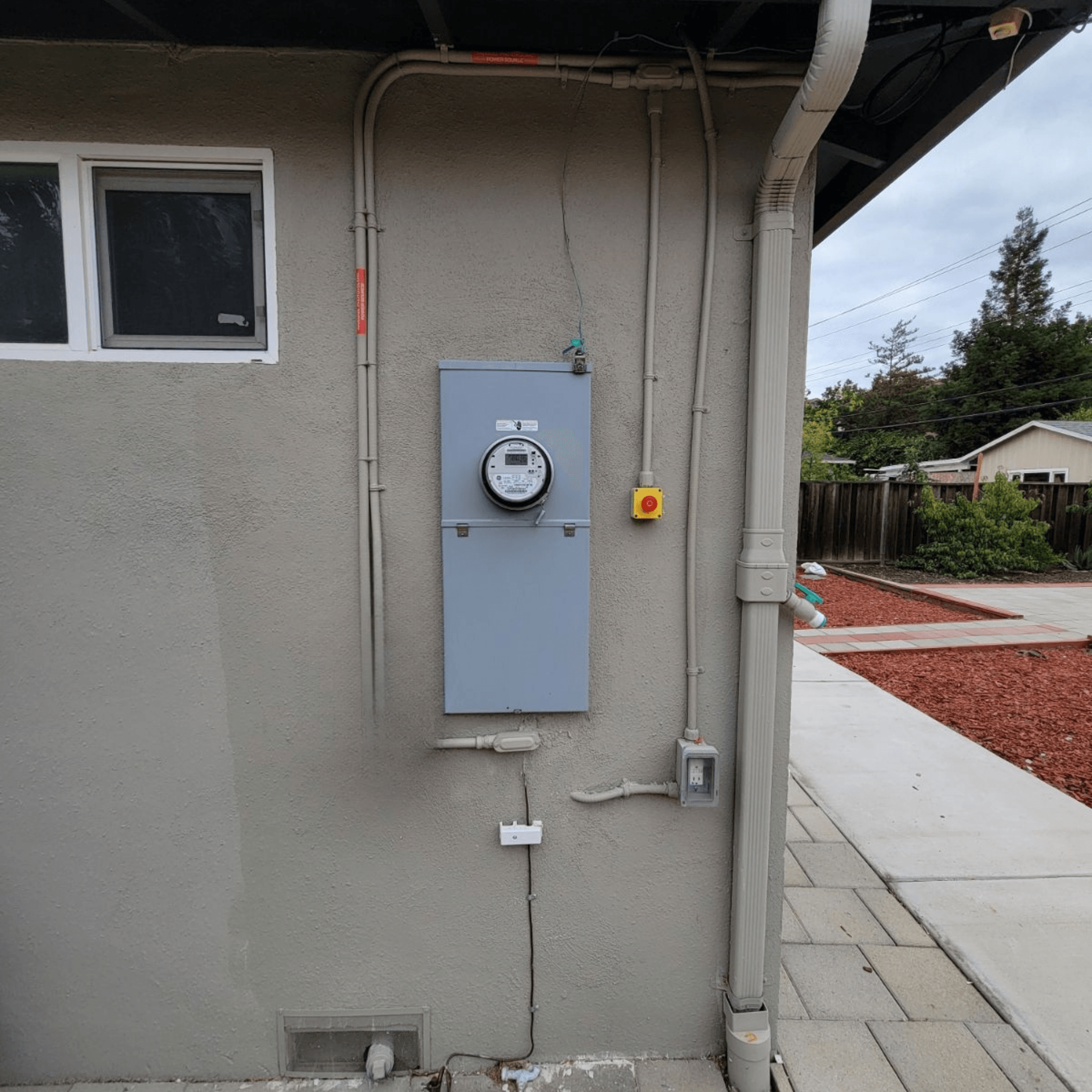 Licensed electrician inspecting a residential main electrical panel before installing solar and battery storage